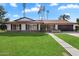 Ranch style home with lush green lawn and a long walkway leading to the entrance at 4421 W Laurie Ln, Glendale, AZ 85302