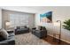 Cozy living room with two gray sofas, a rug, and floor lamps at 4421 W Laurie Ln, Glendale, AZ 85302