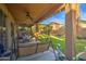 Covered patio with seating area, ceiling fans, and a grassy yard at 46107 W Morning View Ln, Maricopa, AZ 85139