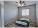 Bright bedroom with ceiling fan, window blinds, and wood-look floors at 46107 W Morning View Ln, Maricopa, AZ 85139