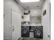 Laundry room with washer, dryer, and stylish tile backsplash at 46107 W Morning View Ln, Maricopa, AZ 85139