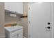 Bright laundry room with utility sink, cabinets, and hanging hooks at 5089 S Harvest St, Gilbert, AZ 85298