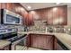 Well-equipped kitchen featuring dark wood cabinets and tile backsplash at 5450 E Deer Valley Dr # 1180, Phoenix, AZ 85054