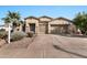 Two-story house with tan exterior, two-car garage, and landscaped front yard at 6229 S Moccasin Trl, Gilbert, AZ 85298