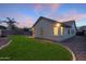 Spacious backyard with grass and a view of the house at dusk at 6497 S Twilight Ct, Gilbert, AZ 85298