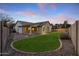 Landscaped backyard with grass, fire pit, and a view of the house at 6497 S Twilight Ct, Gilbert, AZ 85298