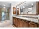 Spa-like bathroom featuring double sinks, granite counters, and a large mirror at 7175 E Camelback Rd # 207, Scottsdale, AZ 85251