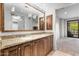 Elegant bathroom with granite countertops, double sinks, and wood cabinets at 7175 E Camelback Rd # 207, Scottsdale, AZ 85251