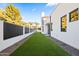 Well-maintained backyard featuring artificial turf and modern black fencing along the side of the house at 8255 E Morgan Trl, Scottsdale, AZ 85258