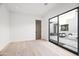 Minimalist bedroom with wood floors, a large glass sliding door, and neutral decor at 8255 E Morgan Trl, Scottsdale, AZ 85258