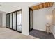 Welcoming entryway with wood accents, stylish light fixture, and seamless transition to outdoor area at 8255 E Morgan Trl, Scottsdale, AZ 85258