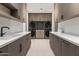 Spacious laundry room with dual washers and dryers, ample counter space, and custom cabinetry at 8255 E Morgan Trl, Scottsdale, AZ 85258