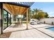 Covered outdoor patio featuring a dining table, lounge seating, and views of the landscaped yard at 8255 E Morgan Trl, Scottsdale, AZ 85258