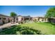 Spacious backyard with putting green, patio furniture, and mature trees at 8277 E Tailspin Ln, Scottsdale, AZ 85255