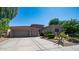 Single-story home with a two-car garage and landscaped yard at 8277 E Tailspin Ln, Scottsdale, AZ 85255