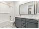 Modern bathroom with double vanity, soaking tub, and grey cabinetry at 8569 N 175Th Ln, Waddell, AZ 85355