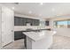 Modern kitchen with gray cabinetry, white quartz island, and stainless steel appliances at 8569 N 175Th Ln, Waddell, AZ 85355