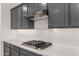 Modern gas cooktop with gray shaker cabinets and white subway tile backsplash at 8569 N 175Th Ln, Waddell, AZ 85355