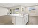 Kitchen island with sink, white cabinets, and views to backyard at 10229 N 177Th Dr, Waddell, AZ 85355