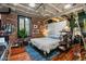 Large bedroom with hardwood floors and exposed brick walls at 114 W Adams St # 203, Phoenix, AZ 85003
