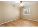 Bright bedroom featuring a ceiling fan, light-colored walls, wood-look floors, and a window at 11825 S 46Th St, Phoenix, AZ 85044