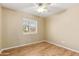 Neutral bedroom with a ceiling fan, wood floors, and natural light from the window at 11825 S 46Th St, Phoenix, AZ 85044
