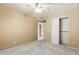 Neutral bedroom with a ceiling fan, carpet, and closet with sliding doors at 11825 S 46Th St, Phoenix, AZ 85044