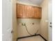 Functional laundry room featuring overhead cabinets, tile flooring, and utility connections at 11825 S 46Th St, Phoenix, AZ 85044