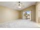 Bright main bedroom featuring carpet floors, a ceiling fan and a door leading to the bathroom at 11825 S 46Th St, Phoenix, AZ 85044