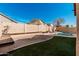 Backyard featuring a block wall, artificial grass, gravel and desert landscaping at 13550 W Port Au Prince Ln, Surprise, AZ 85379