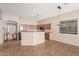 Open kitchen with tile floors, stainless appliances, wood cabinets, and an island with seating at 13550 W Port Au Prince Ln, Surprise, AZ 85379