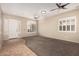 Inviting living room with neutral tones, tile entry, carpeted floor, and shuttered windows at 13550 W Port Au Prince Ln, Surprise, AZ 85379