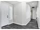 Hallway with light gray walls, white trim, luxury vinyl plank flooring, and a glimpse into other rooms at 1612 E Zion Way, Chandler, AZ 85249