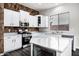 Kitchen featuring white cabinets, granite countertops, stainless appliances and beautiful rock accent wall at 1612 E Zion Way, Chandler, AZ 85249