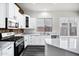 This kitchen features white cabinets, stainless appliances, and an accent stone wall above the counter at 1612 E Zion Way, Chandler, AZ 85249