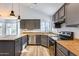 Modern kitchen with gray cabinets, stainless steel appliances, and wood countertops at 19009 N 25Th Pl, Phoenix, AZ 85050