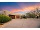 Two-car garage with wood doors and desert landscaping at 34587 N Ironwood Rd, Scottsdale, AZ 85266