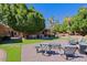 Spacious backyard with patio furniture, putting green, and mature trees at 4222 E Mclellan Cir # 7, Mesa, AZ 85205