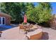 Relaxing flagstone patio with fire pit, seating area, and shade umbrella at 4222 E Mclellan Cir # 7, Mesa, AZ 85205