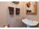 Clean bathroom with pedestal sink and wood-framed mirror at 5731 W Aster Dr, Glendale, AZ 85304