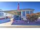 Mobile home with covered porch, landscaping, and American flag at 7750 E Broadway Rd # 156, Mesa, AZ 85208
