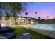 Evening view of a backyard oasis with a pool and patio at 1209 E Marigold Ln, Tempe, AZ 85288