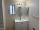 Updated bathroom with white vanity and oval mirror at 13013 N 19Th Pl, Phoenix, AZ 85022