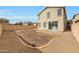 View of the exterior of the house highlighting the large yard with a rock perimeter at 13441 W Rose Ln, Litchfield Park, AZ 85340