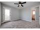 Bright bedroom with carpeted floor, ceiling fan, and access to a private balcony at 13441 W Rose Ln, Litchfield Park, AZ 85340