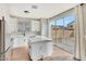 Modern kitchen with white cabinets, stainless steel fridge, island, and glass door access to patio at 13441 W Rose Ln, Litchfield Park, AZ 85340