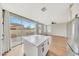 Open kitchen with white island, stainless steel fridge, and sliding doors to backyard at 13441 W Rose Ln, Litchfield Park, AZ 85340