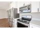 Stainless steel appliances and white cabinetry in kitchen at 13441 W Rose Ln, Litchfield Park, AZ 85340