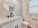 Modern powder room with a floating vanity, round mirror, and black faucet at 13441 W Rose Ln, Litchfield Park, AZ 85340