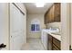 Bright laundry room with washer, dryer, and ample cabinet space at 13462 E Wethersfield Rd, Scottsdale, AZ 85259